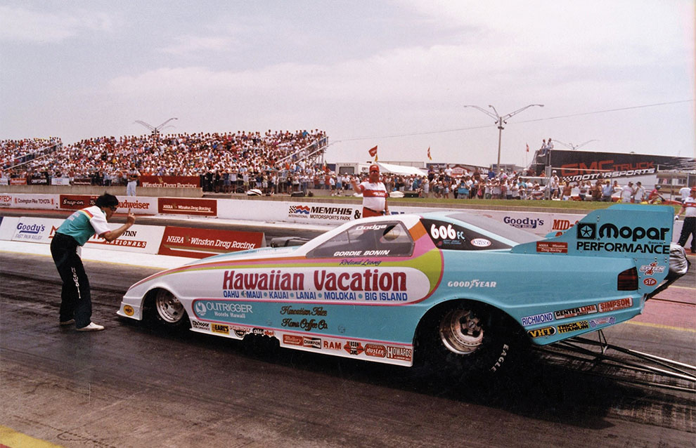 a race car on a track with a crowd watching