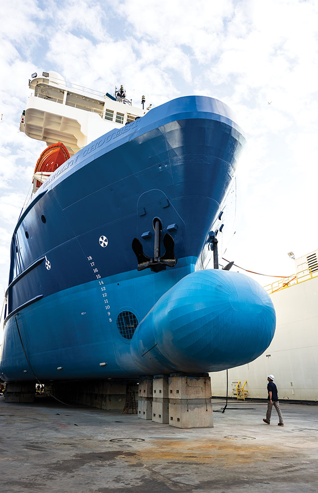 the underside of a massive blue boat. 