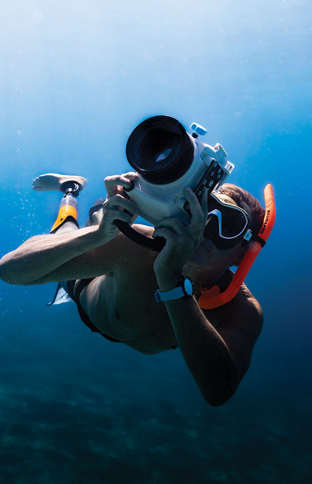 a person in a mask and goggles taking a picture of a camera
